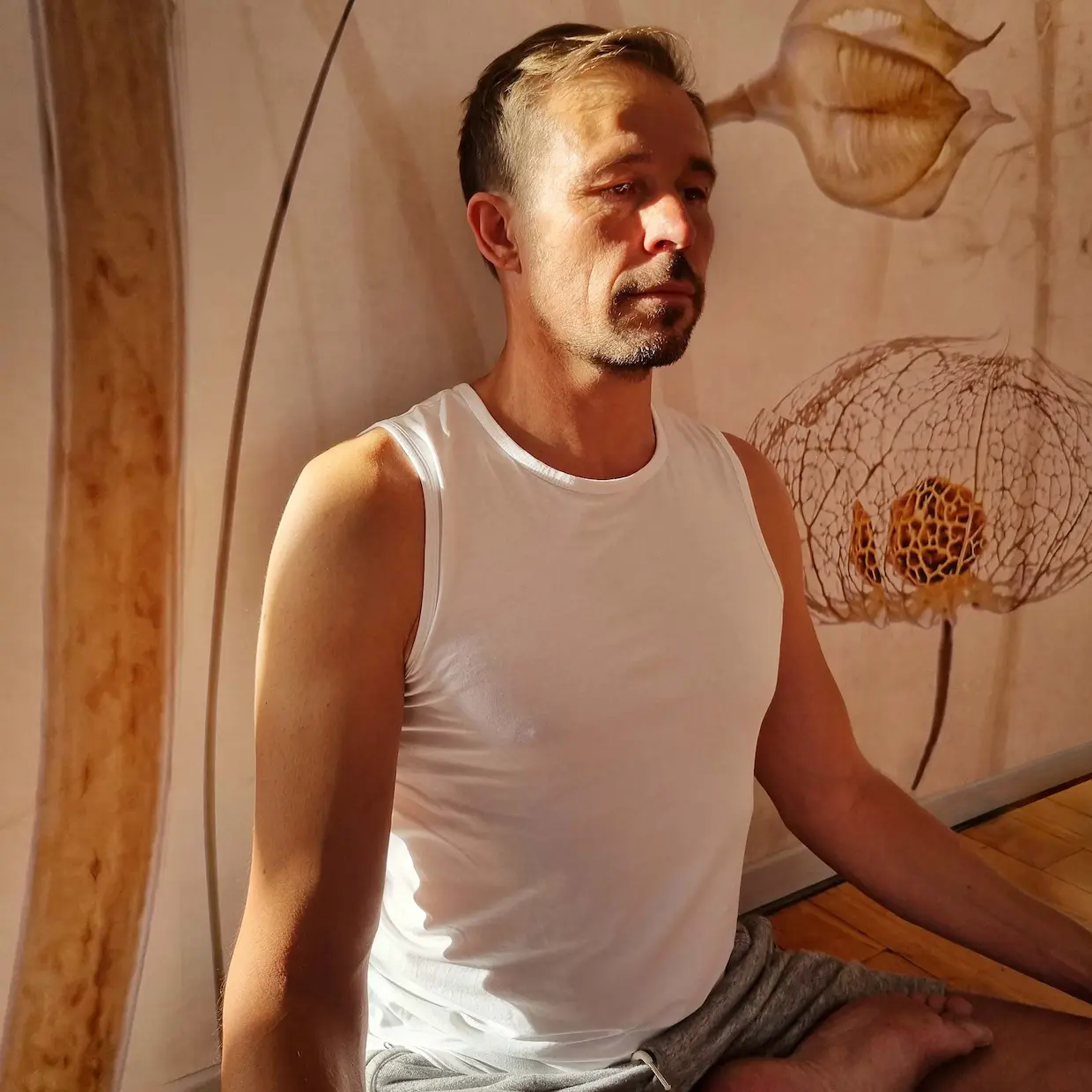 Christoph in einer sitzenden Yoga-Meditationspose mit natürlichem Licht.